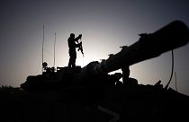 Un soldado armado encima de un tanque en Gaza.