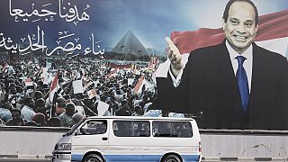 A minibus passes under a billboard supporting Egyptian President Abdel Fattah el-Sissi for the presidential elections, in Cairo, Egypt on Sunday