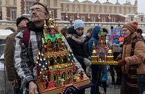 يُرى المشاركون وهم يستعرضون مشاهد المهد التي صنعوها في مسابقة مشهد ميلاد المسيح السنوية في كراكوف في ساحة السوق الرئيسية في البلدة القديمة في كراكوف، 7 ديسمبر 2023.