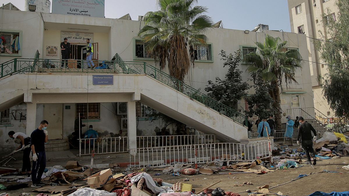 فلسطينيون يتفقدون الأضرار الناجمة عن القصف الإسرائيلي عل مستشفى الشفاء في مدينة غزة. 26.11.23  