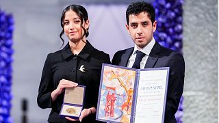 كيانا رحماني وعلي رحماني يقفان مع الجائزة نيابة عن والدتهما خلال حفل جائزة نوبل للسلام لعام 2023 في قاعة مدينة أوسلو في 10 ديسمبر 2023.