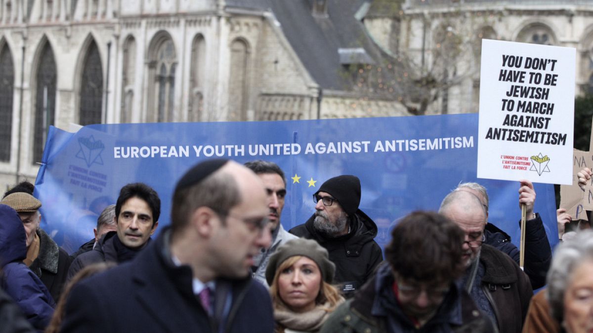 Demonstranten halten Schilder, während sie bei einer Antisemitismus-Kundgebung in Brüssel am Sonntag, den 10. Dezember 2023, demonstrieren.