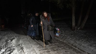 Mulheres carregam as suas bagagens após terem atravessado a fronteira com a Rússia, na região ucraniana de Sumy, a 22 de novembro.