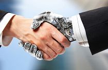 A human and a robot shake hands.