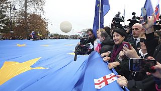 Georgia's President Salome Zourabichvili, second right, with other demonstrators carry a gigantic EU flag during a march in support of Georgia's EU candidacy in Tbilisi