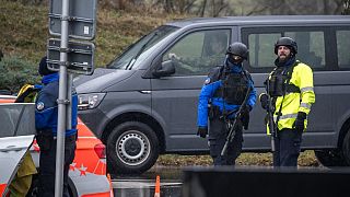 Police officers control cars near Saint Maurice, as they search for a gunman who killed two people and injured another in the southern Swiss town of Sion, on December 11, 2023