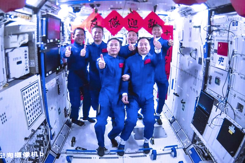 The crews of Shenzhou-15 and Shenzhou-16 taking a group pictures inside the core module Tianhe of China's space station, May 2023