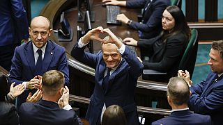 Donald Tusk muestra un corazón, con sus manos, a los legisladores, tras ser elegido primer ministro de Polonia en el Parlamento de Varsovia, el lunes 11 de diciembre de 2023.