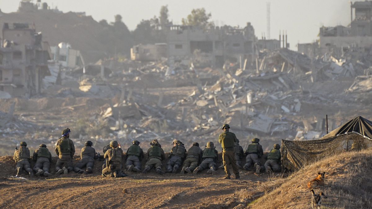 Soldati israeliani con le macerie in lontananza 