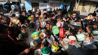 Gazze Şeridi'nin güneyinde Mısır sınırına yakın Refah semtinde yemek alabilmek için sırada bekleyen Filistinliler