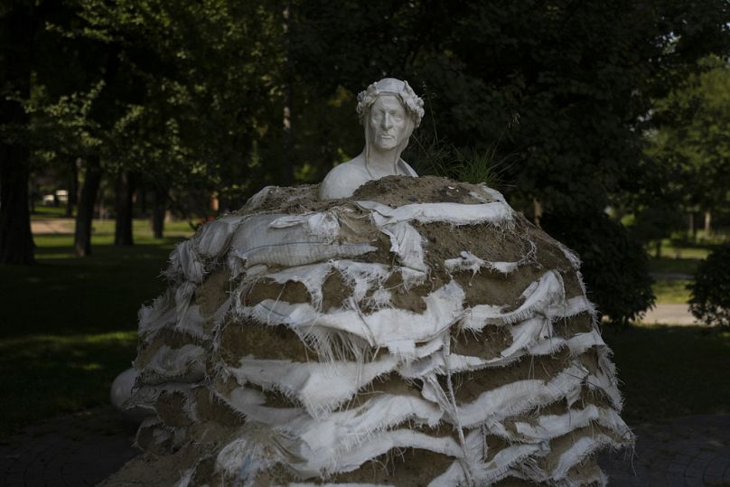 Des sacs de sable usés sont empilés autour du monument à Dante Alighieri pour protéger la statue d'un éventuel bombardement par la Russie à Kiyv, juillet 2023.