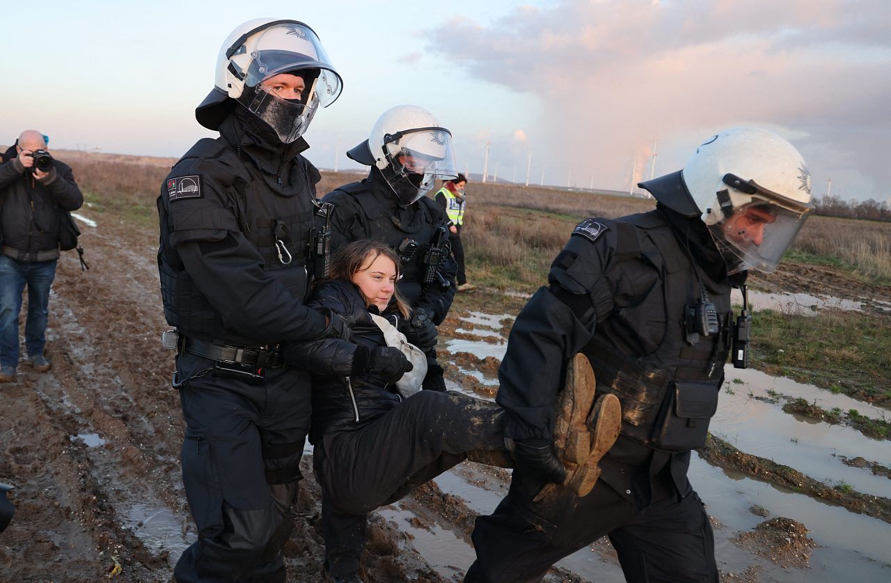 Police officers carry Swedish climate activist Greta Thunberg (C) out of a group of demonstrators and activists in Erkelenz, western Germany in January.
