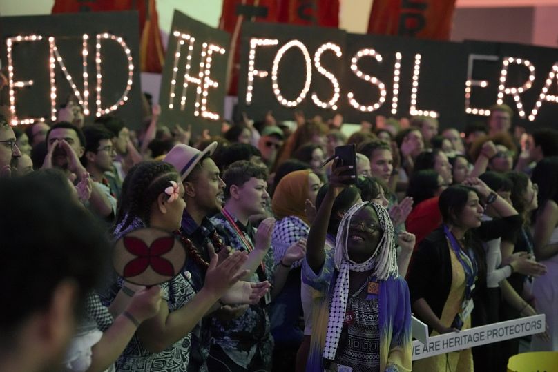 Activist Ina-Maria Shikongo takes photos during a demonstration to end fossil fuels at COP28.