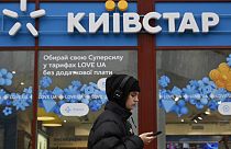 Una mujer pasa junto a una tienda de Kyivstar en Kiev este martes