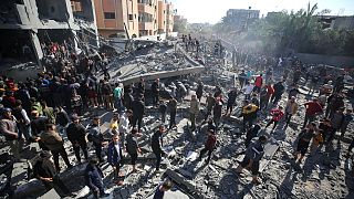 Imagen de ciudadanos palestinos en las ruinas de un edifico de la Franja de Gaza, que ha quedado devastado por los bombardeos de Israel.