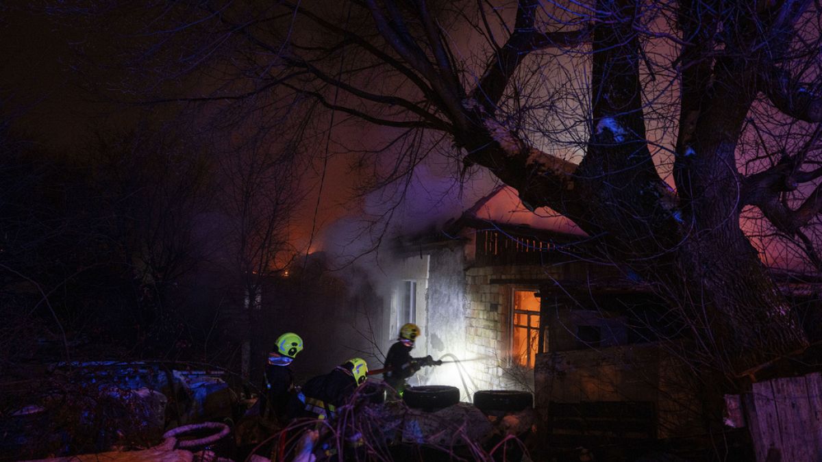 Rescue workers extinguish a fire at a residential house after a Russian rocket attack in Kyiv, Ukraine, Wednesday, Dec. 13, 2023.