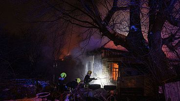 Rescue workers extinguish a fire at a residential house after a Russian rocket attack in Kyiv, Ukraine, Wednesday, Dec. 13, 2023.