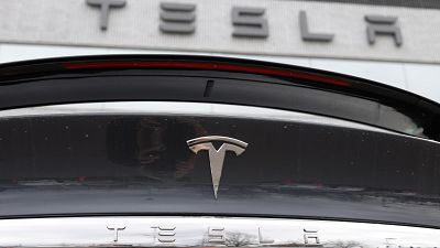 FILE - The Tesla company logo shines off the rear deck of an unsold 2020 Model X at a Tesla dealership, April 26, 2020, in Littleton, Colo. 