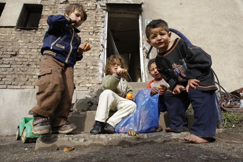 Roma children playing while eating fruits in front of their temporarily accommodation in downtown Sarajevo, Bosnia, Friday, Nov. 12, 2010.
