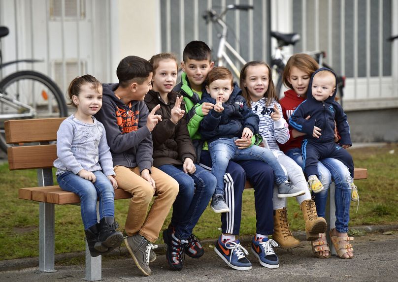 Migrant children sit on a bench and flash the victory sign as they wait for the visit of German President Joachim Gauck in Bergisch Gladbach, western Germany.