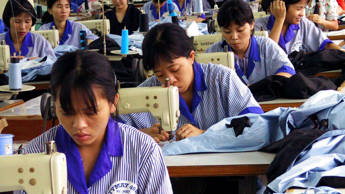  عمال فيتناميون يستخدمون آلات الخياطة في مصنع ملابس تديره الدولة لتصنيع الملابس الرياضية للأسواق الأوروبية والأمريكية في هانوي- 3 سبتمبر 2001.