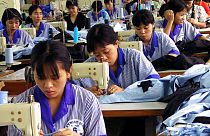  عمال فيتناميون يستخدمون آلات الخياطة في مصنع ملابس تديره الدولة لتصنيع الملابس الرياضية للأسواق الأوروبية والأمريكية في هانوي- 3 سبتمبر 2001.