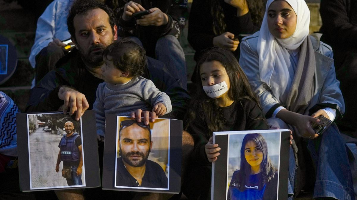  عائلة تحمل صور الصحفيين اللبنانيين الذين قتلوا في الغارات الإسرائيلية، خلال احتجاج أمام المتحف الوطني اللبناني في بيروت، لبنان 8 ديسمبر 2023