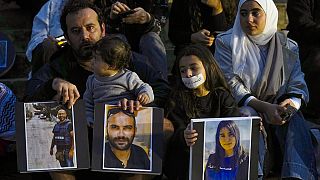  عائلة تحمل صور الصحفيين اللبنانيين الذين قتلوا في الغارات الإسرائيلية، خلال احتجاج أمام المتحف الوطني اللبناني في بيروت، لبنان 8 ديسمبر 2023