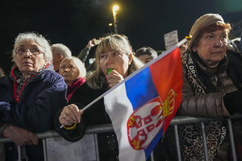 A woman waves a Serbian flag during a final pre-election rally of opposition "Serbia against violence" coalition in Belgrade, Serbia, Tuesday, Dec. 12, 2023