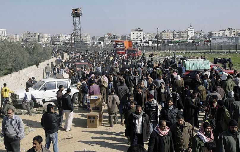 فلسطينيون يتجمعون في الشارع الرئيسي في رفح بعد عبور الحدود المصرية من غزة إلى مصر