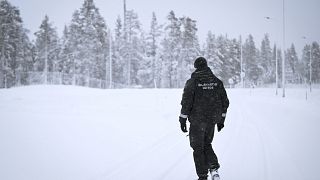 A Finnish Border Guard walks in the snow at the Raja-Jooseppi international border crossing station between Russia and Finland, in Inari, northern Finland, Saturday, Nov. 25, 