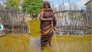 عبدية شيخ عبد الله، 70 عامًا، تقف في الماء بجوار منزلها الذي غمرته المياه في مقاطعة مانديرا، كينيا، الأربعاء 13 ديسمبر 2023.