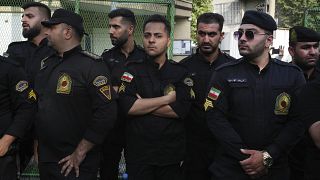 ضباط شرطة إيرانيون يقفون للحراسة أثناء احتجاج ضد السويد أمام السفارة السويدية في طهران