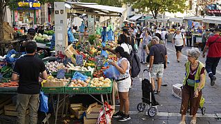 People shop at a street grocery market in Marseille, France, Thursday, Sept. 14, 2023.