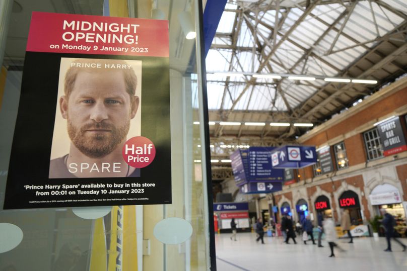 A poster advertises the midnight opening at a store selling the memoir "Spare' by Prince Harry.