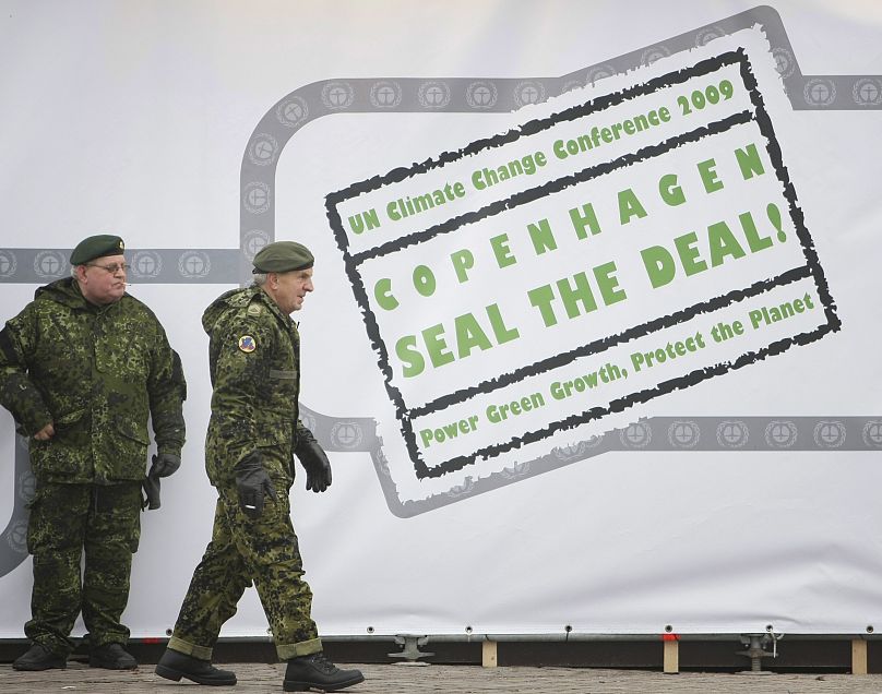 Danish military appear next to a sign reading "Copenhagen Seal the Deal" in the centre of Copenhagen in 2009.