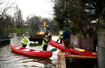 يقوم عمال المدينة بإعارة قارب كاياك لإحدى السكان المحليين للسماح لها بالتنقل بينما يغمر نهر شارينت مدينة كونياك جنوب غرب فرنسا، في 15 ديسمبر 2023.