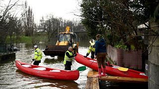 يقوم عمال المدينة بإعارة قارب كاياك لإحدى السكان المحليين للسماح لها بالتنقل بينما يغمر نهر شارينت مدينة كونياك جنوب غرب فرنسا، في 15 ديسمبر 2023.