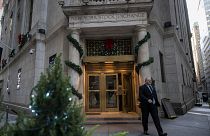 People walk in and out of the New York Stock Exchange (NYSE) at Wall Street on December 14, 2023 in New York City. Global equities made cautious gains Thursday with Frankfurt 