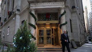 People walk in and out of the New York Stock Exchange (NYSE) at Wall Street on December 14, 2023 in New York City. Global equities made cautious gains Thursday with Frankfurt 