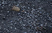 A hand grenade is seen on the road at the entrance of the freed village of Hrakove, Ukraine, Tuesday, Sept. 13, 2022