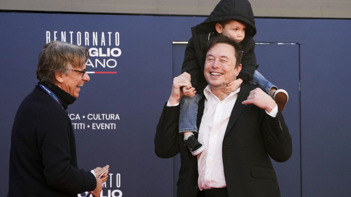 Elon Musk con uno de sus hijos en el foro Atreju