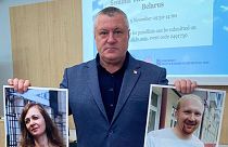 Активистка из Беларуси Леанид Судаленко держит портреты заключенных журналистов Ларисы Щираковой и Евгения Меркиса