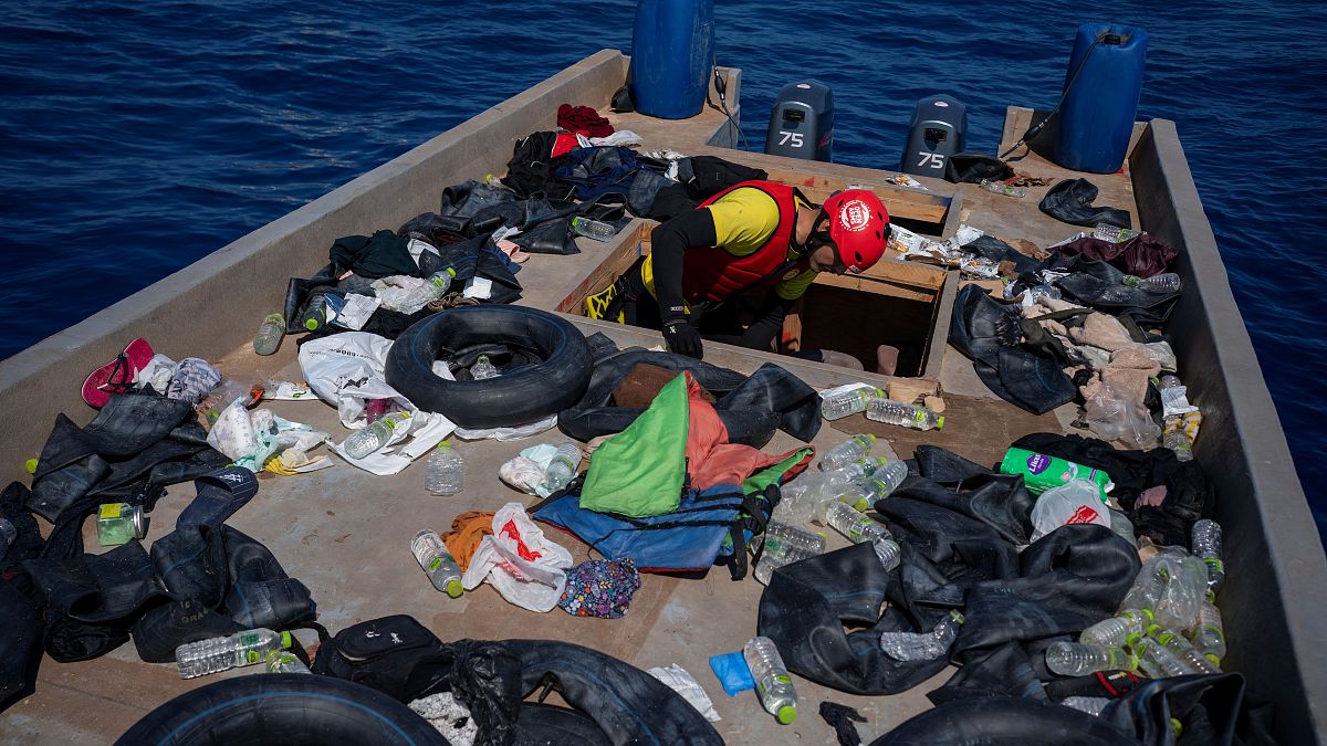 أحد أفراد منظمة إسبانية يتفقد قاربا للمهاجرين على بعد 30 كلم من السواحل الليبية