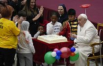 Pope Francis blows a candle on a cake as he celebrates his birthday 