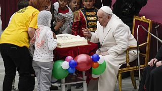 Ferenc pápa elfújja a gyertyát a születésnapi tortáján a Vatikánban 2023. december 17-én