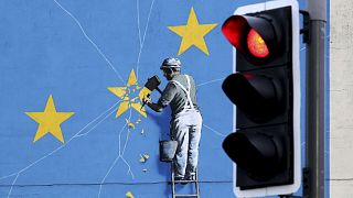 Вид на фреску Бэнкси Brexit, изображающую человека, отламывающего флаг ЕС, в Дувре, Англия, вторник, 11 декабря 2018 года.