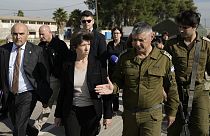 French Foreign Minister Catherine Colonna, center left, talks with Israeli Col. Olivier Rafowicz as she arrives at the Shura military base, central Israel on Sunday