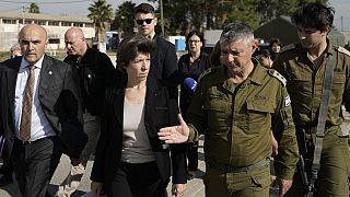 French Foreign Minister Catherine Colonna, center left, talks with Israeli Col. Olivier Rafowicz as she arrives at the Shura military base, central Israel on Sunday