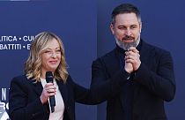 Leader of the Spanish far-right VOX party Santiago Abascal, right, stands on the stage with Italy's Prime Minister Giorgia Meloni during a Brothers of Italy party celebration 